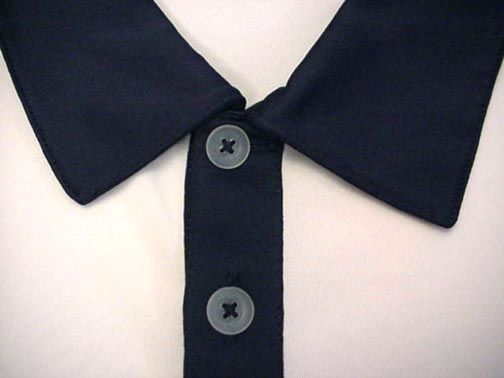 The sleeves are trimmed in College Navy. On the left chest is a 